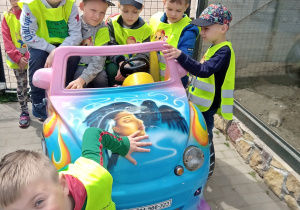 Chłopcy z grupy 6-latków na przejażdzce samochodem -zabawką